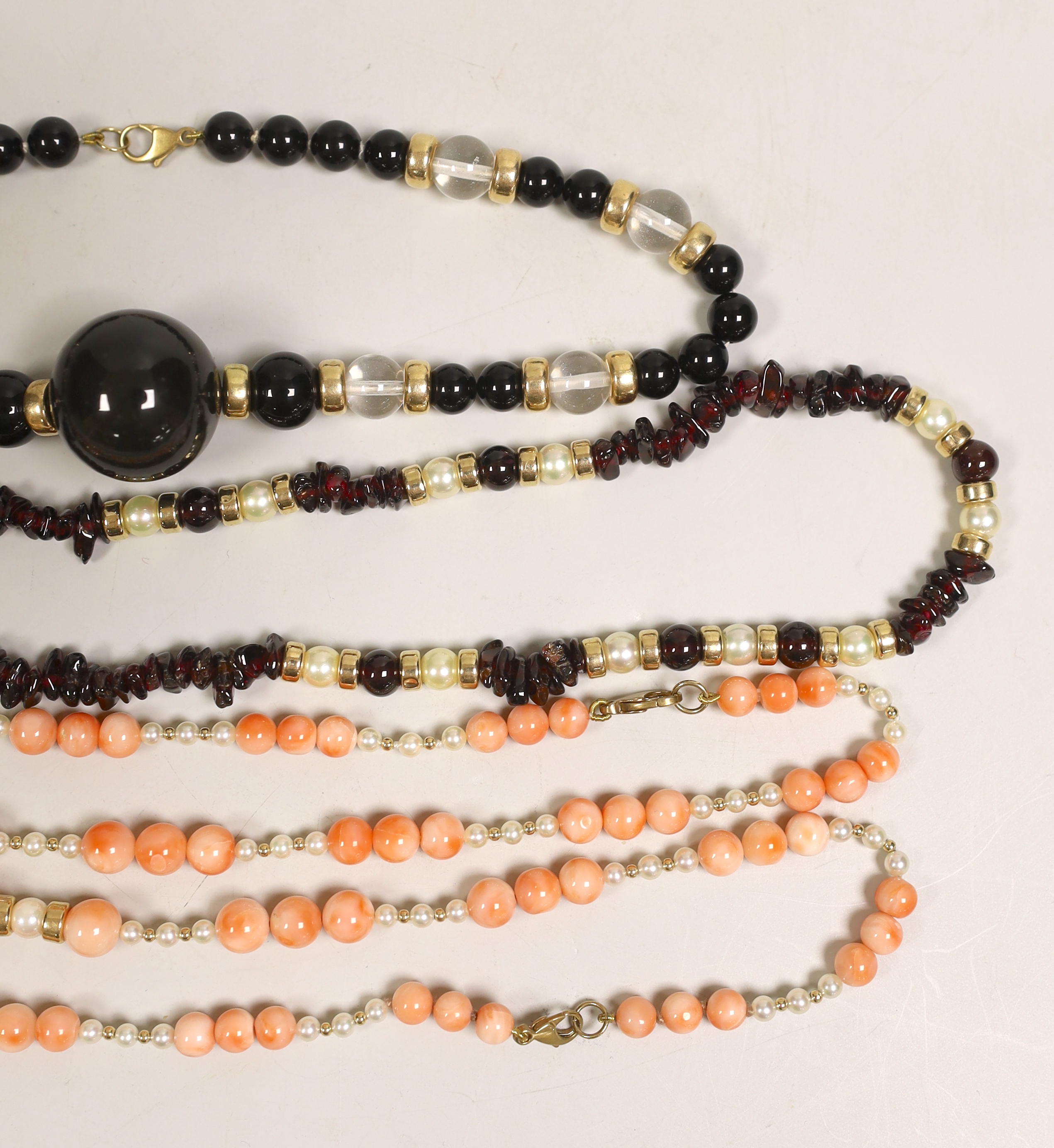 A modern garnet and cultured pearl necklace with yellow metal spacers and clasp, 48cm and three other necklaces.